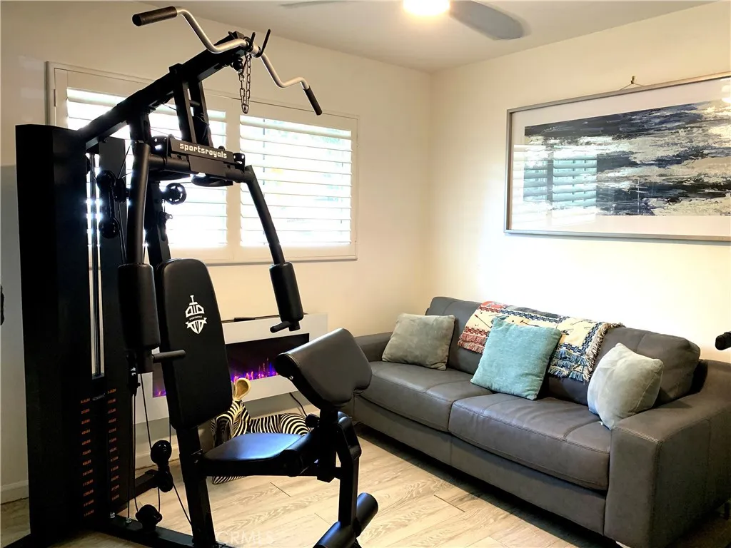 Second bedroom at 4772 Excelente Drive shown with existing physical furniture, workout equipment, and a couch.