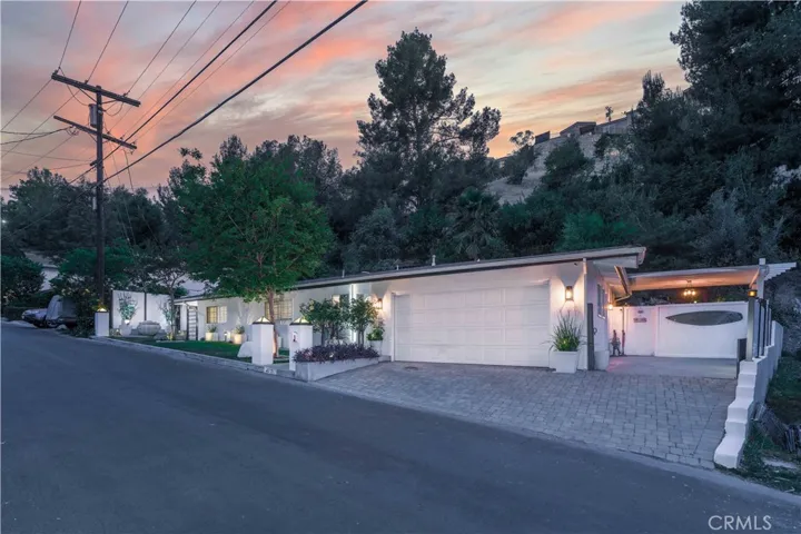 Front exterior evening twilight view of 4772 Excelente Drive in Woodland Hills at sunset.