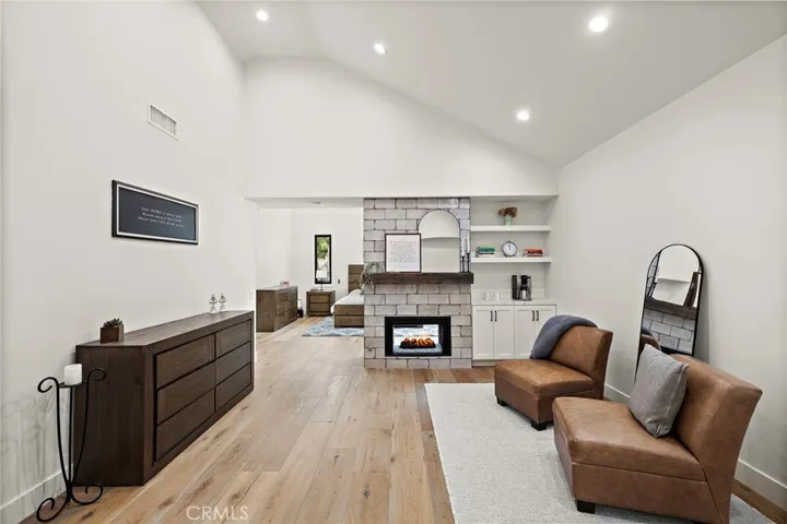 Sitting area with dual sided fireplace in primary suite is the perfect home office, gym or reading room.