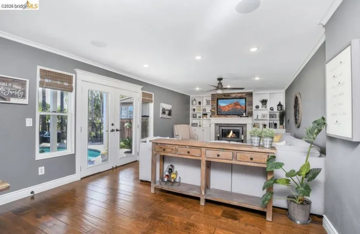 Wood-finish flooring throughout, featuring a living area with a fireplace and built-in shelving
