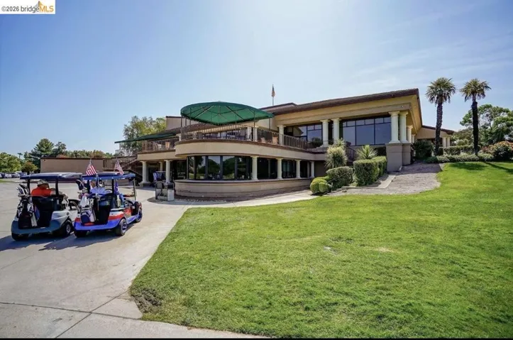 Clubhouse exterior featuring a classical architectural style with large windows and a second-story balcony