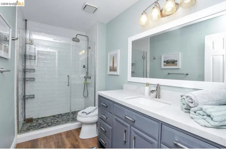 Full bathroom featuring a glass-enclosed shower with pebble flooring and a rainfall showerhead