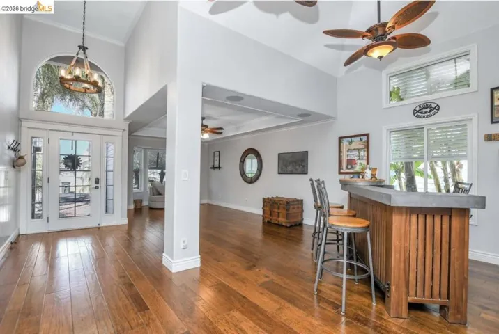 Grand entry featuring a vaulted ceiling and an arched transom window above double glass-paneled doors