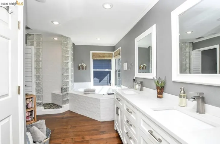 Dual vanity with undermount sinks, white cabinetry, and brushed nickel fixtures
