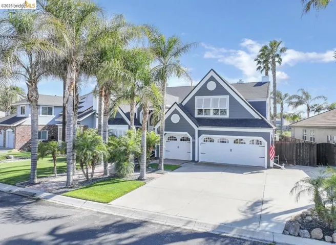 Two-story residence featuring a blue siding exterior with white trim, two attached garages, and a concrete driveway