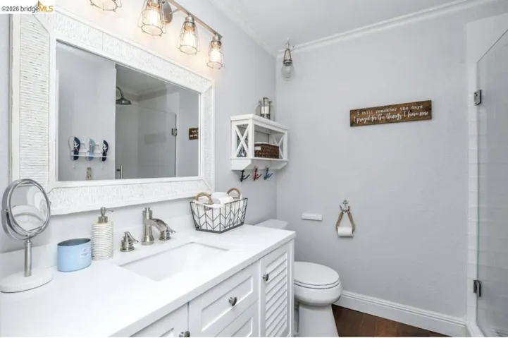 Bathroom featuring a white vanity with an integrated sink, brushed nickel faucet, and a large framed mirror