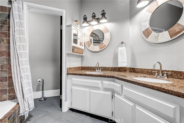 Primary ensuite bath provides dual sinks, plentiful cabinet space & custom lighting