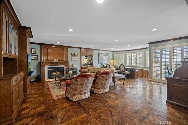 Huge den with custom wood built-ins/mantel/floor.