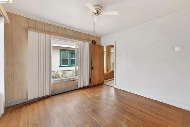 Hardwood flooring and a white ceiling fan with light fixture