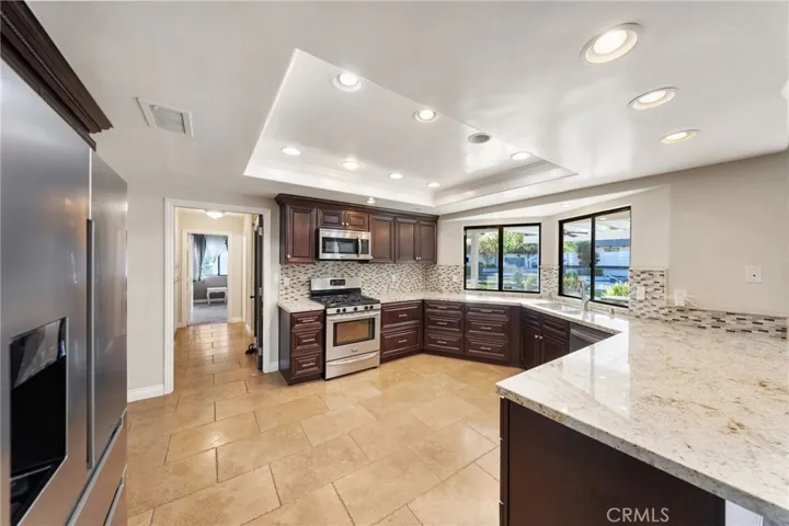 kitchen with granite counters and backsplash, stainless appliances, and canned lighting