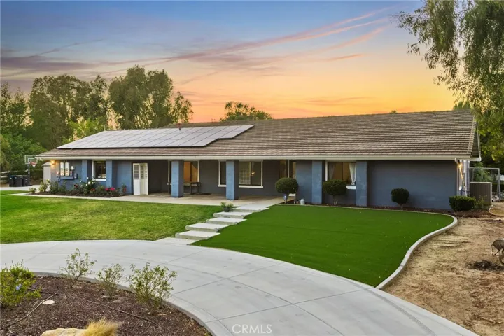 turf and grass with circular driveway all the way around steps to entry way