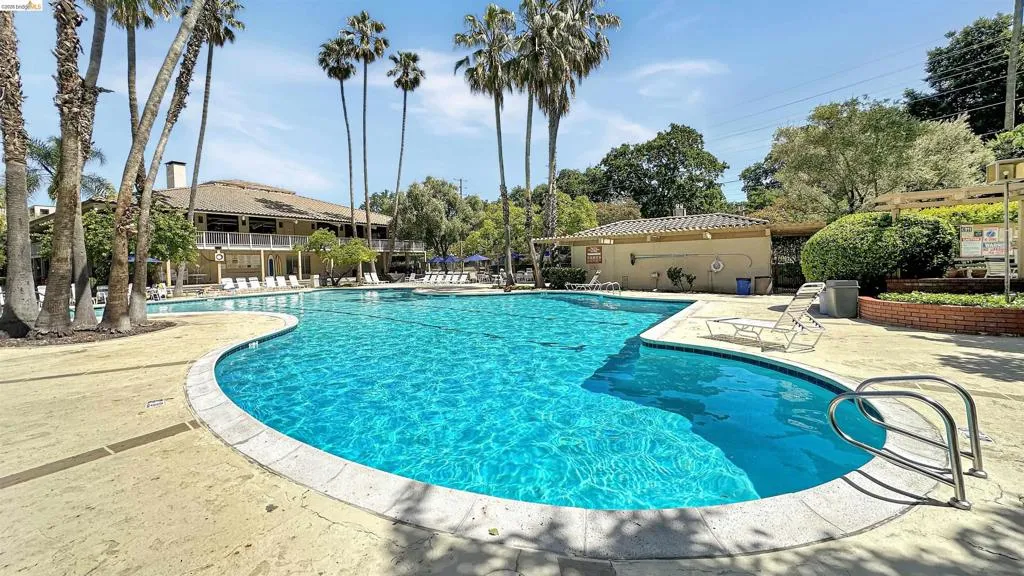 Resort-style pool area featuring a large free-form swimming pool with integrated spa