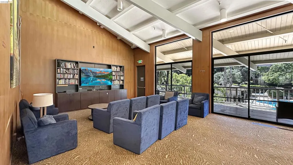 Vaulted ceiling with exposed beams and wood-finish paneling