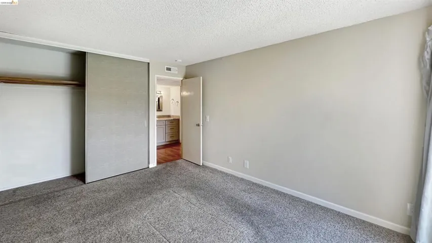 Carpeted room with light neutral walls and white trim