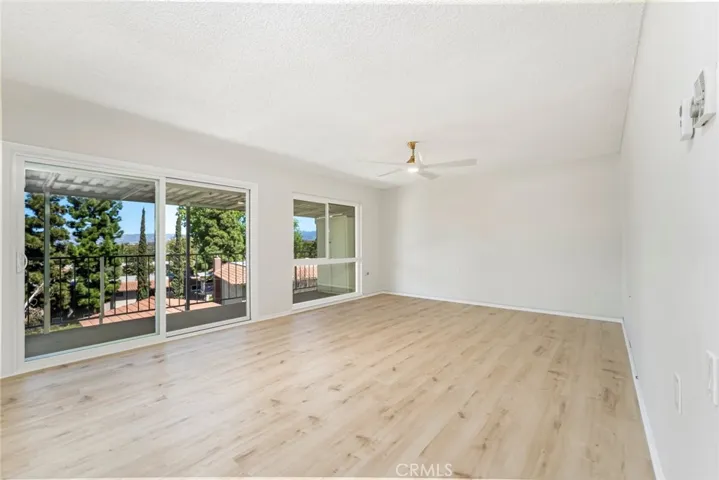 Luxury vinyl plank flooring, sliding glass doors to balcony with a view.