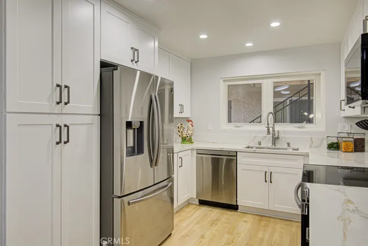 Newer dual pane windows have been installed over the stainless sink.  The dishwasher, freestanding range and microwave are all stainless steel too.
