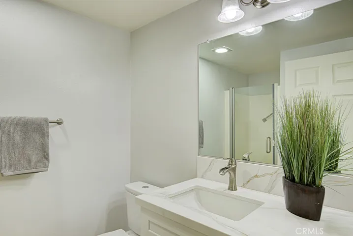 Fresh and clean Guest Bathroom has a high vanity with Shaker Style Cabinets and Quartz Counters.