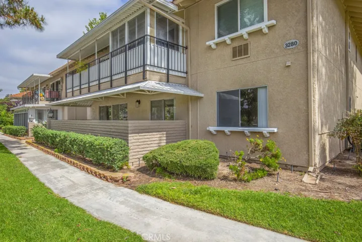 View of the condo looking toward the greenbelt and sidewalk from the upper level and carport.