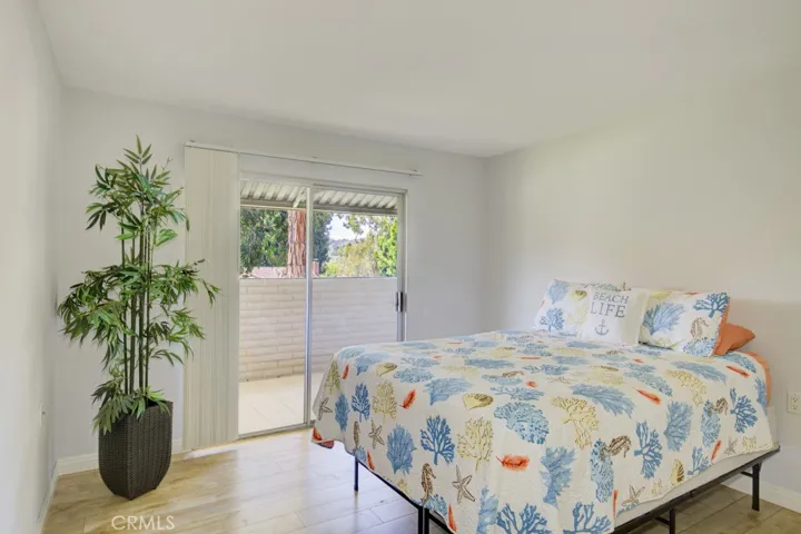 The Guest Bedroom enjoys a view to the treed greenbelt through a sliding door.