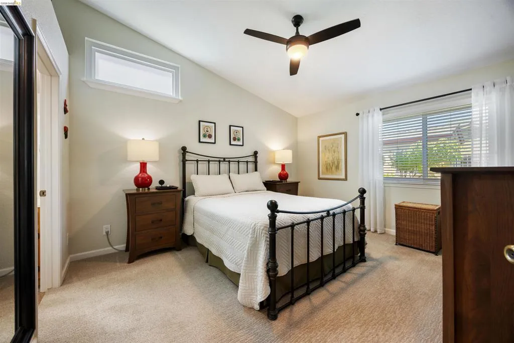 Bedroom featuring vaulted ceilings, a contemporary ceiling fan, and carpet flooring