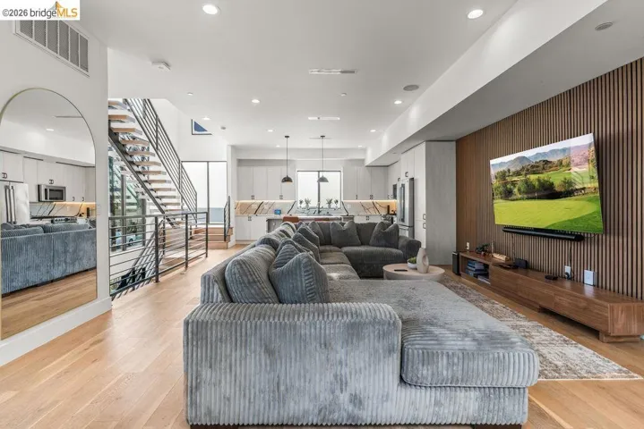 Open-concept living area featuring light wood-finish flooring and a contemporary wood-slat accent wall