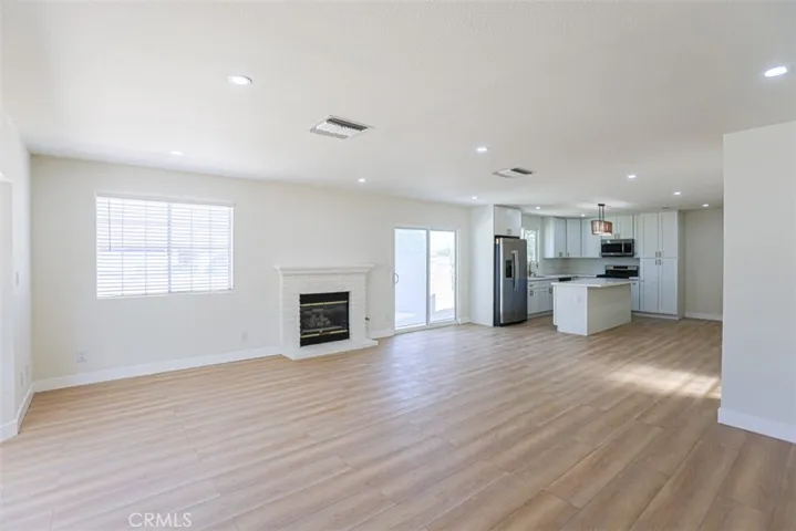 Spacious open-concept living room with brand new flooring and abundant natural light.