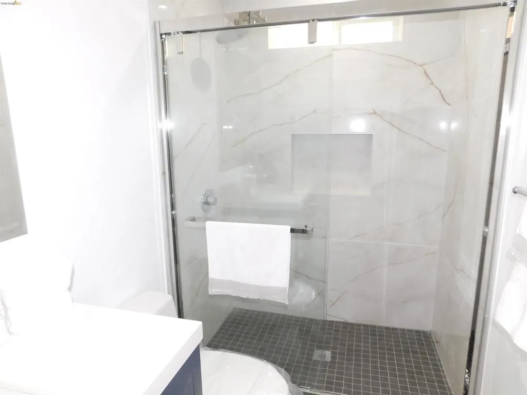 Walk-in shower with clear glass enclosure and chrome hardware