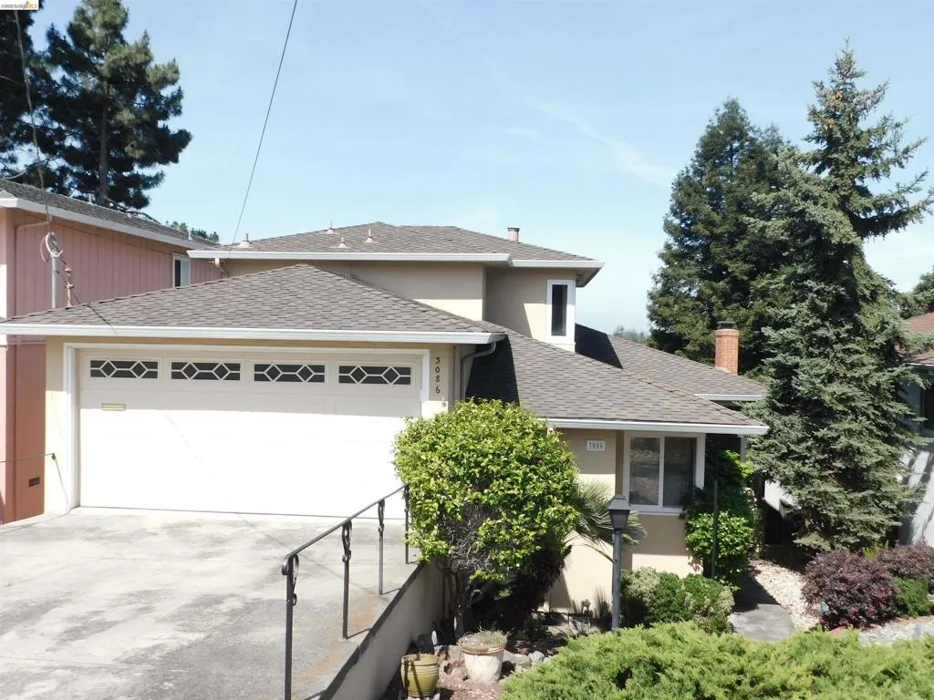 Stucco exterior residence featuring a two-car garage with decorative window inserts