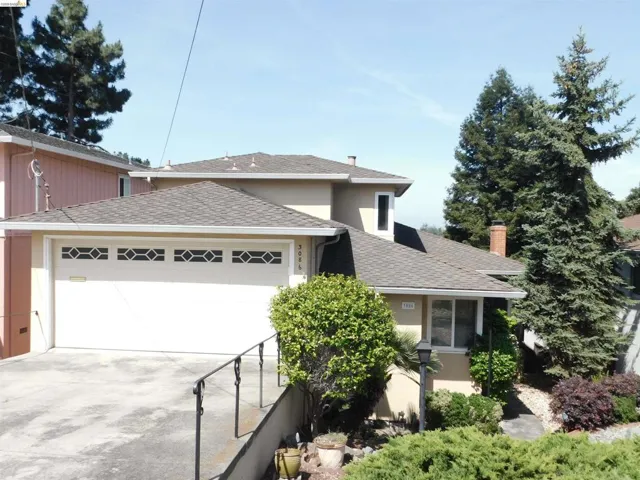 Stucco exterior residence featuring a two-car garage with decorative window inserts