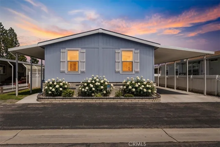 Front of home: 9080 Bloomfield spc 145, Cypress: Digitally Enhanced Front Exterior: Image has been digitally enhanced to show added flowers/landscaping for visualization purposes. Original photo shown adjacent.