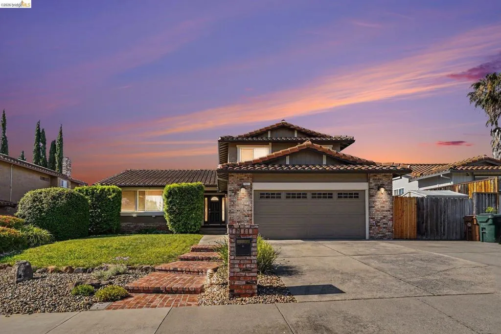 Two-story exterior with a tile roof and brick accents