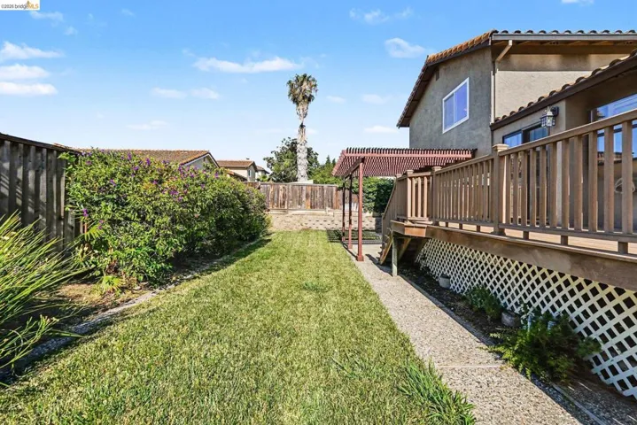 Expansive backyard featuring a lush lawn, privacy fencing, and mature landscaping