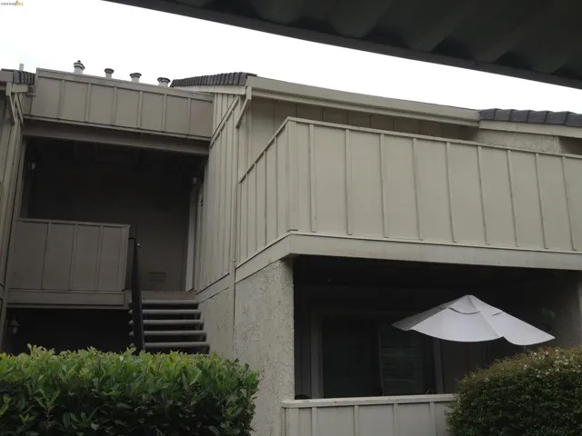 Multi-level exterior with a private balcony featuring a privacy wall