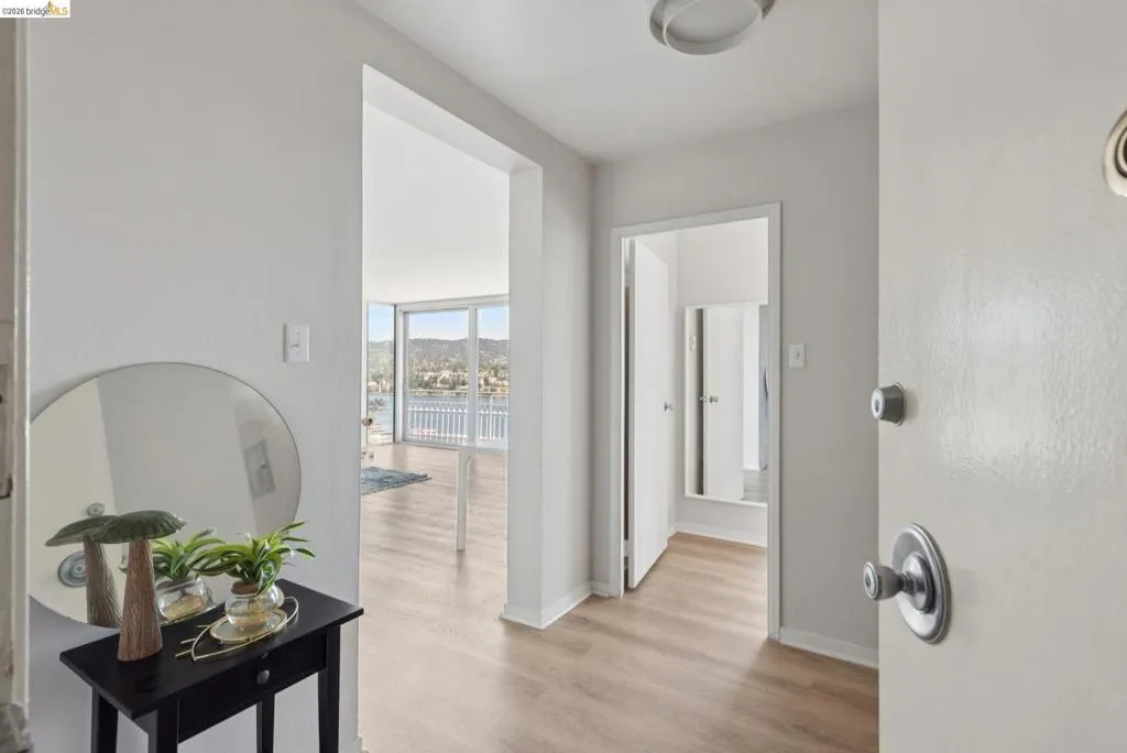 Corridor with light wood-style flooring and baseboards