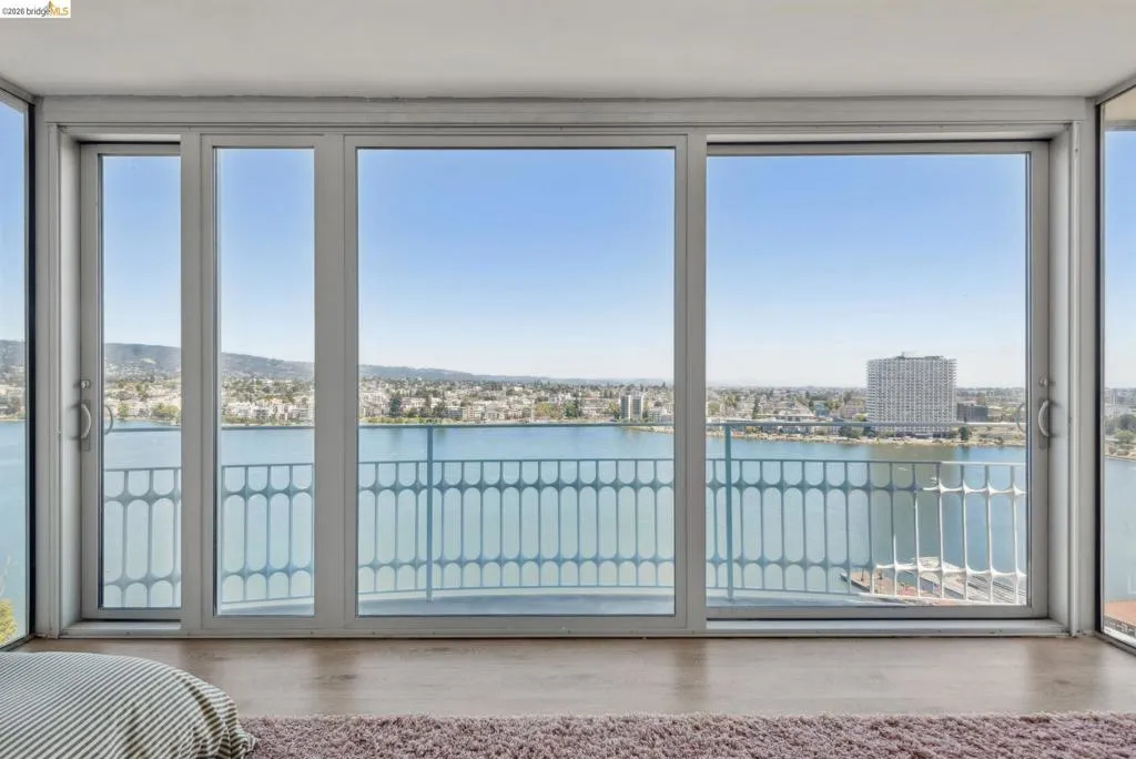 Bedroom featuring a water view, access to outside, and wood finished floors