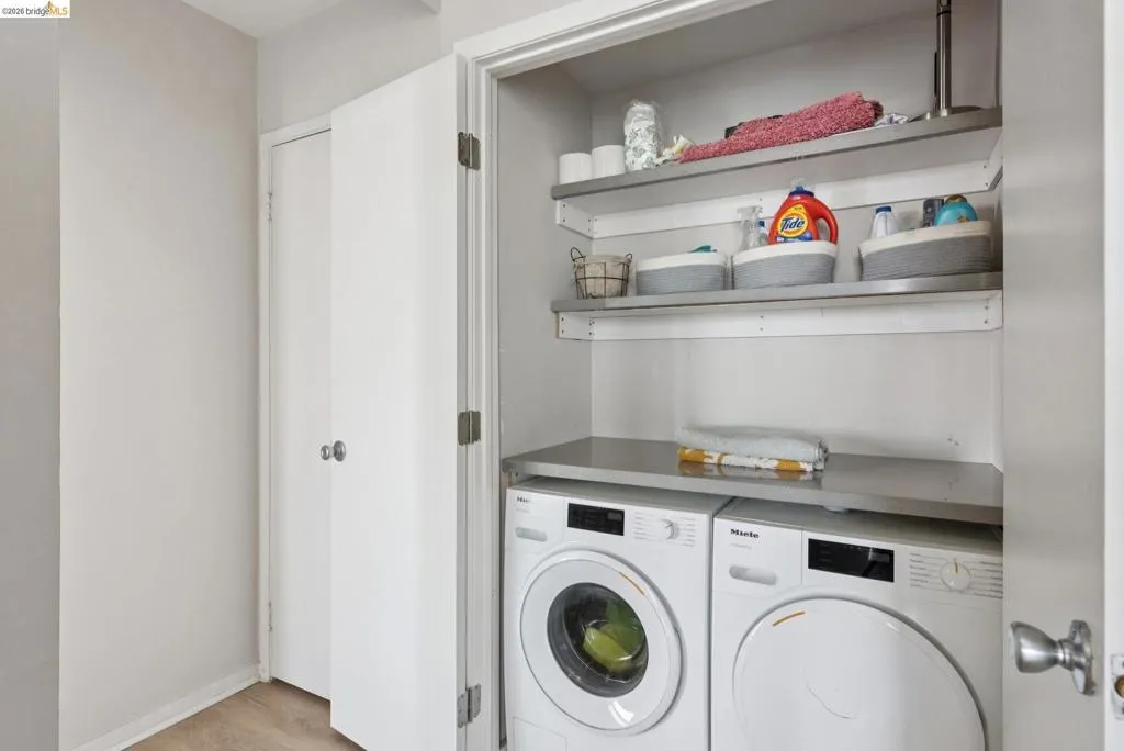 Laundry area with washing machine and dryer and light wood finished floors