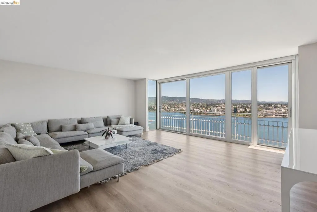 Living area featuring a wall of windows, a water view, and wood finished floors