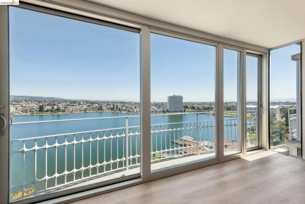 Unfurnished sunroom featuring a water view and a city view