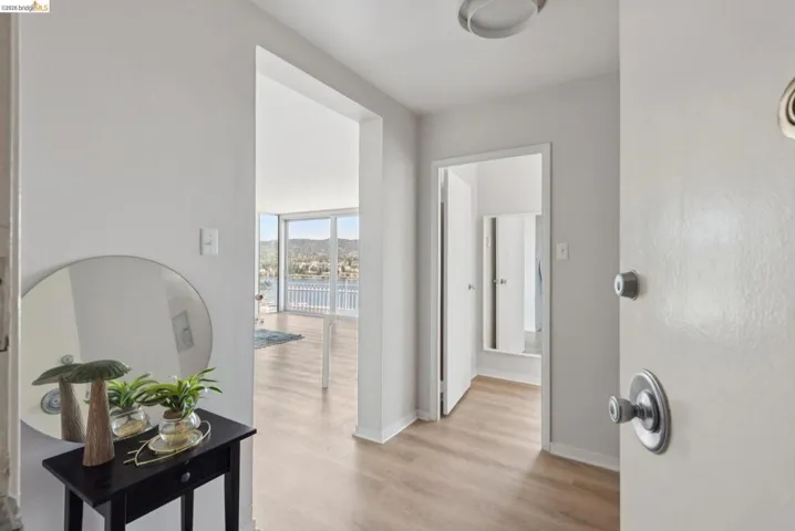 Corridor with light wood-style flooring and baseboards