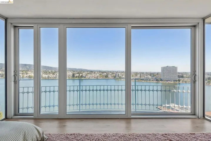 Bedroom featuring a water view, access to outside, and wood finished floors