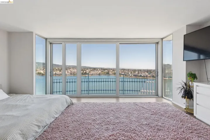 Bedroom featuring a wall of windows, multiple windows, and access to exterior