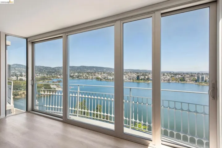Doorway to outside with a water view, wood finished floors, and expansive windows