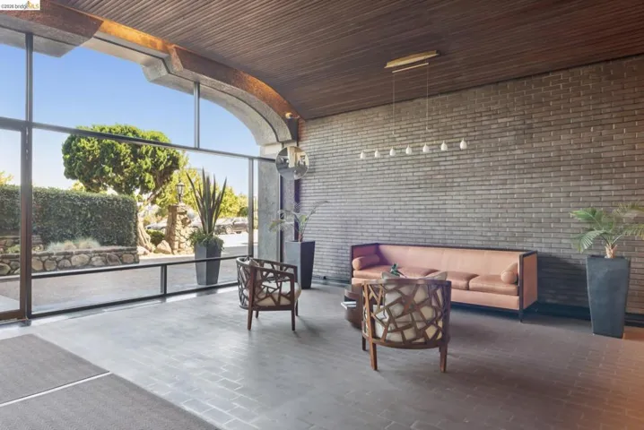 Building lobby featuring brick wall, a wall of windows, and wood ceiling