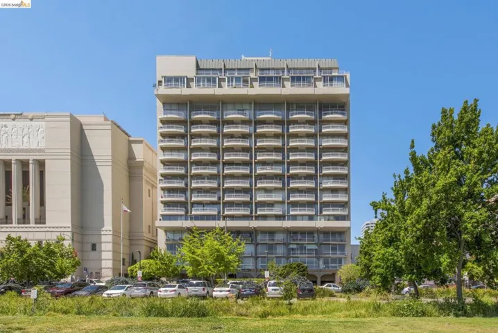 View of apartment building / complex featuring uncovered parking