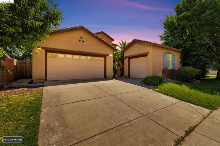 Stucco exterior featuring dual garage doors, a concrete driveway, and a detached single-car garage