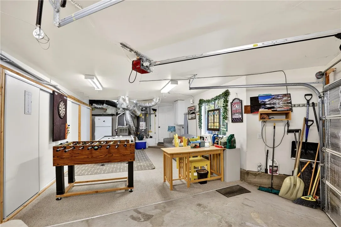 Attached garage turned game room with a full wall of storage space