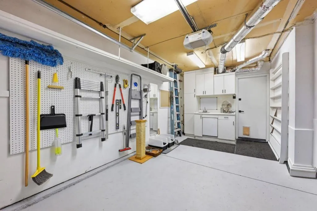 Garage with cabinets, mini-refrigerator and lots of space for storage.