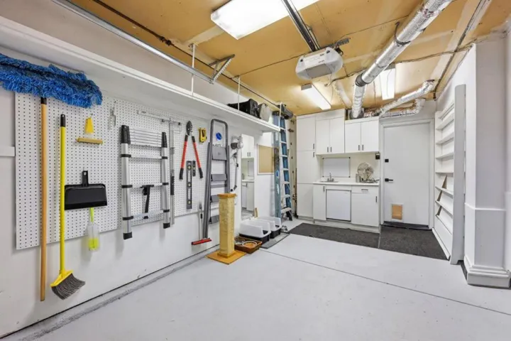 Garage with cabinets, mini-refrigerator and lots of space for storage.