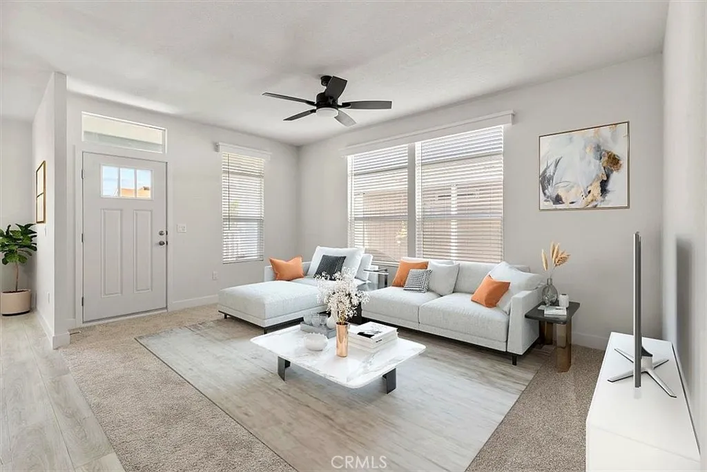 Living Room: Large open living area with updated flooring, recessed lighting, neutral tones, and direct flow to the kitchen and dining spaces.