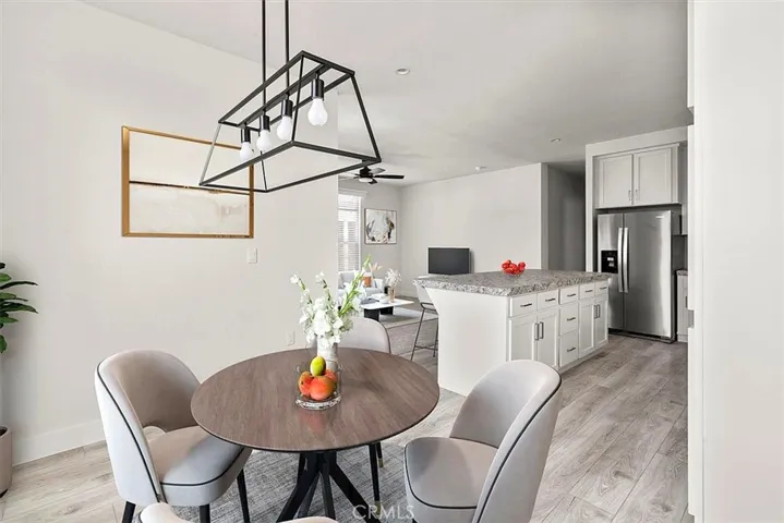 Living Room: Large open living area with updated flooring, recessed lighting, neutral tones, and direct flow to the kitchen and dining spaces.